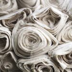 Ein Stapel recycelter Baumwollstoffe in verschiedenen Farben und Mustern, die zur Herstellung von nachhaltigen und umweltfreundlichen Produkten verwendet werden.