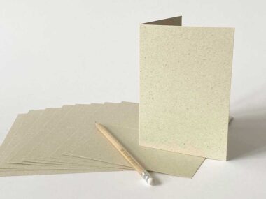 Gefaltete Klappkarte A6 aus Graspapier stehend mit Stift